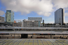 900471 Gezicht over de perronkappen van het Centraal Station te Utrecht op de kantoorgebouwen aan de zuidzijde van Hoog ...